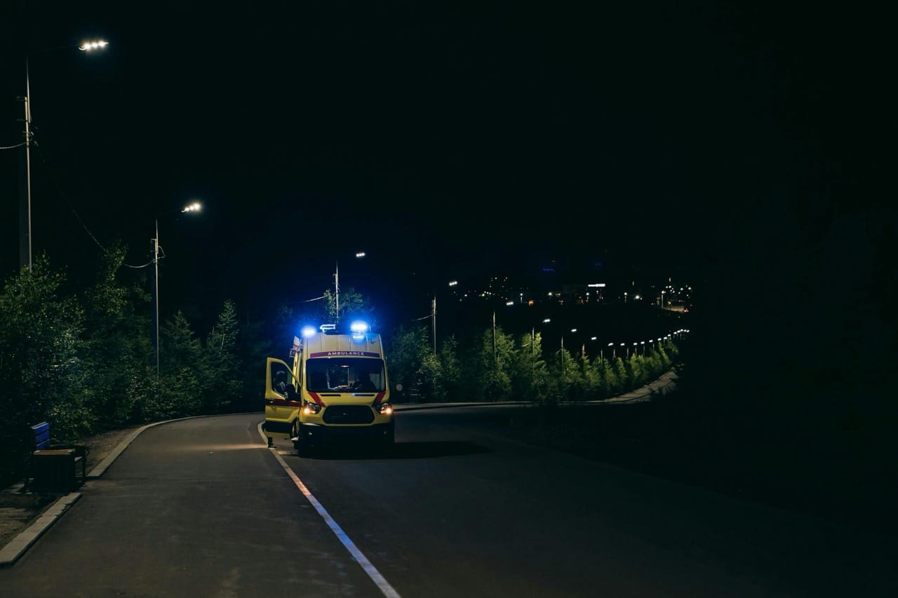 Un camion d'ambulance arrivant dans une rue peu éclairé